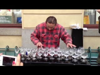 a street musician masterfully plays glasses of water